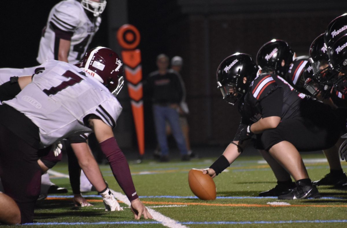Junior center Omar Abu-Saleh gets ready to snap the ball to freshman quarterback Nesai Phok.