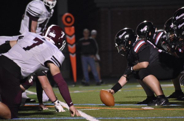 Junior center Omar Abu-Saleh gets ready to snap the ball to freshman quarterback Nesai Phok.
