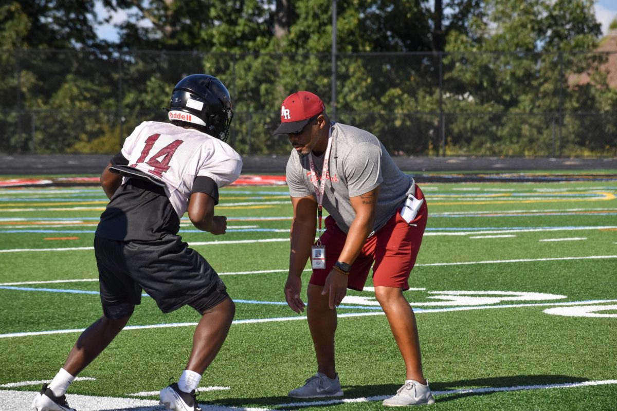 Mark Teague leads a warmup drill during the football team’s practice. “ I'm very aggressive, uptempo,” Teague said. “And I want the kids to feed off of that. I want them to feel as though our coach will run through a wall for us, and we do the same for him.”