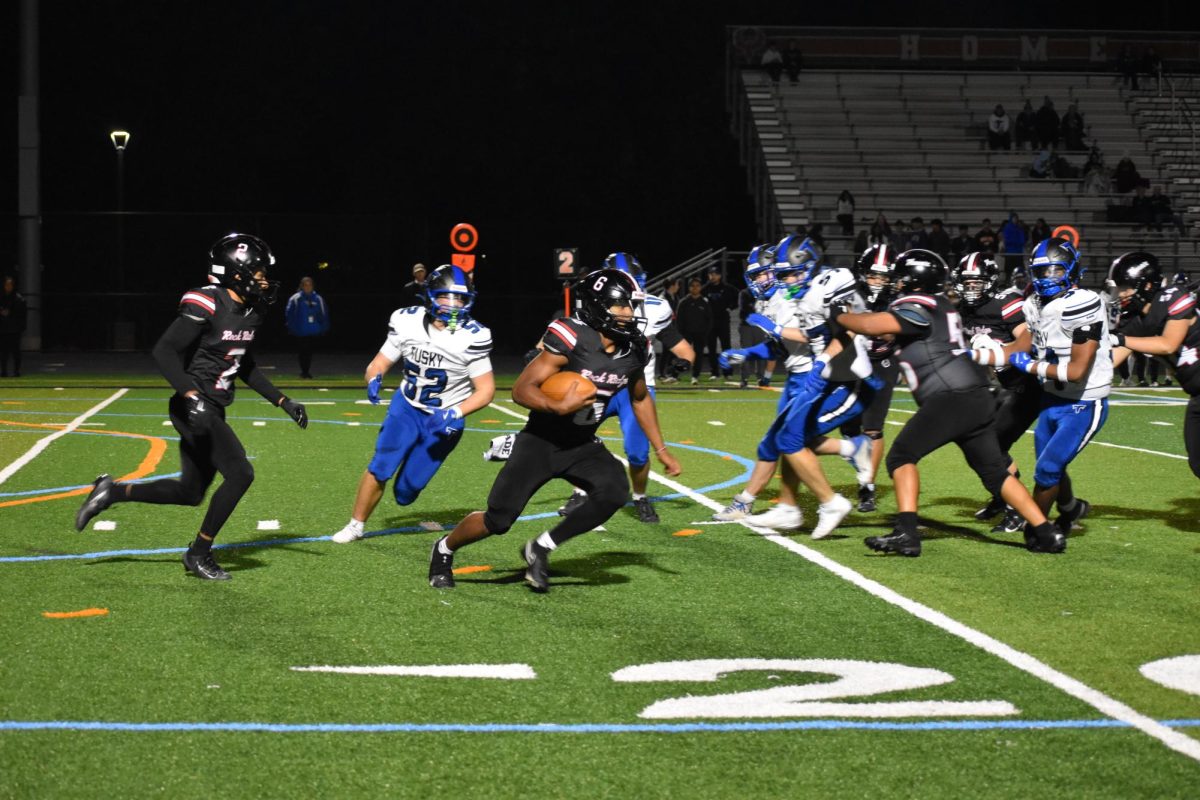 Senior quarterback Xavier Smith clutches the ball as he avoids Tuscarora’s defense.