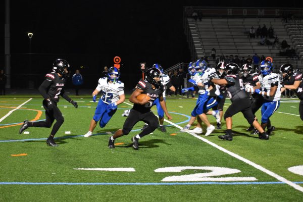Senior quarterback Xavier Smith clutches the ball as he avoids Tuscarora’s defense.