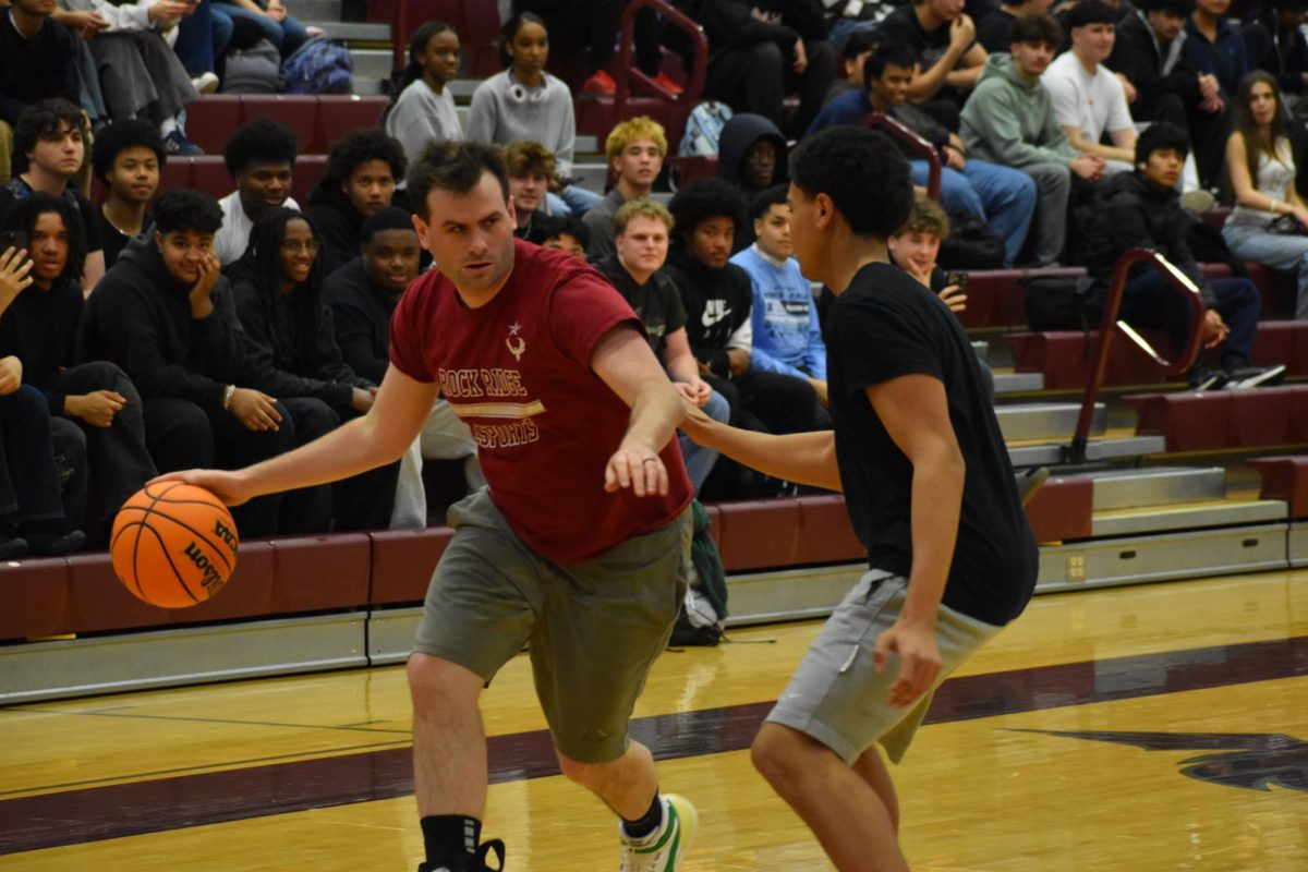 Math teacher Logan Flannigan dribbles the ball up the court.
