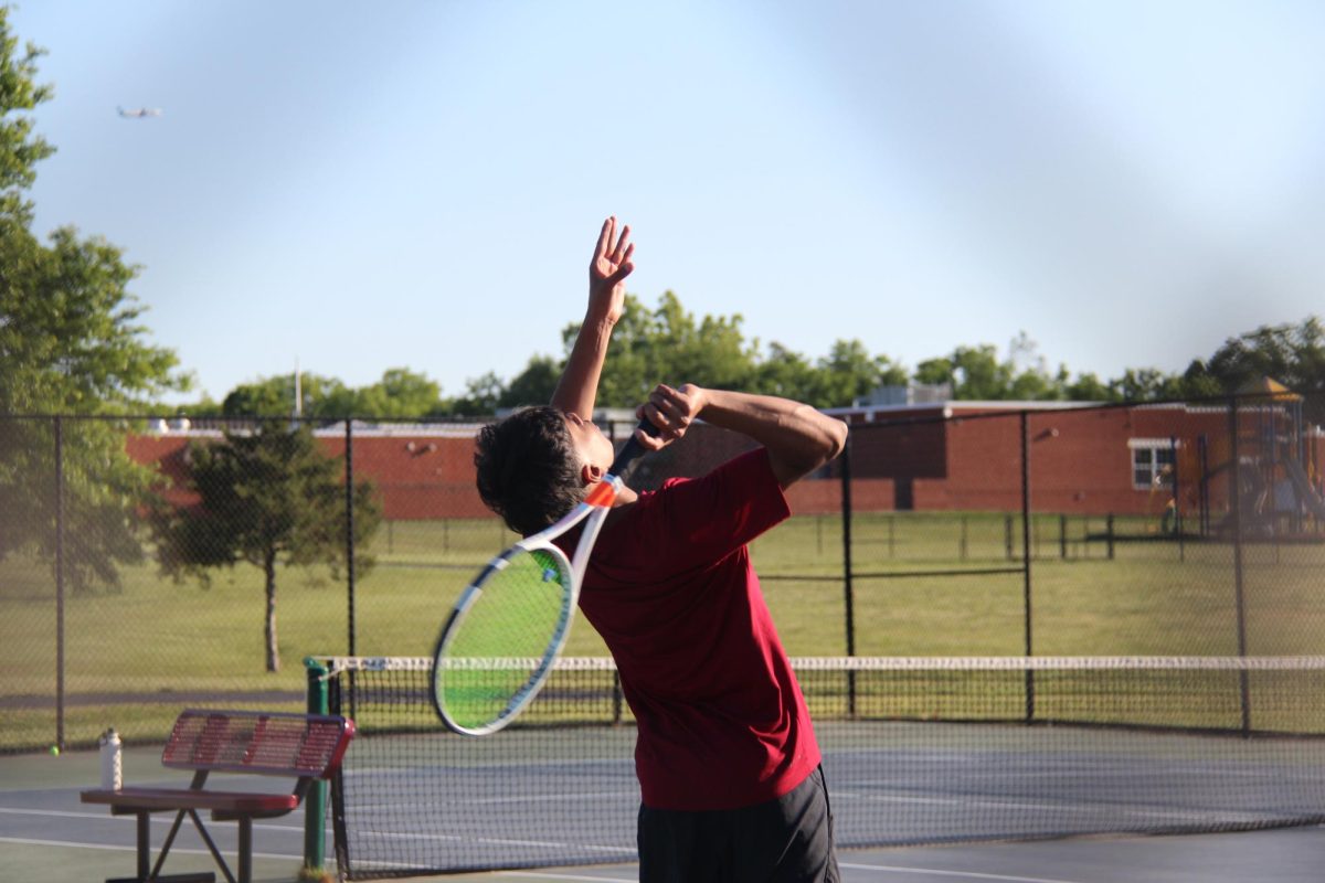 Senior Sreeram Gourineni tosses the ball high in preparation to serve.